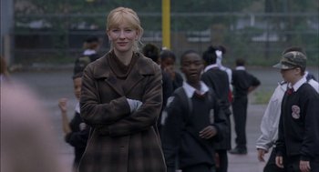 Movie still from “Notes on a Scandal” (2006), directed by Richard Eyre – A woman standing in front of a group of people; Medium shot, Over the shoulder angle