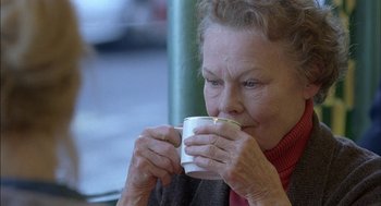 Movie still from “Notes on a Scandal” (2006), directed by Richard Eyre – An older woman is drinking a cup of coffee; Close Up shot, Over the shoulder angle