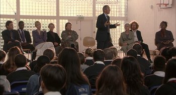 Movie still from “Notes on a Scandal” (2006), directed by Richard Eyre – A group of people sitting in front of an audience; Wide shot, High angle