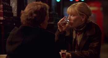 Movie still from “Notes on a Scandal” (2006), directed by Richard Eyre – A woman drinking a glass of wine at a bar; Medium shot, Over the shoulder angle