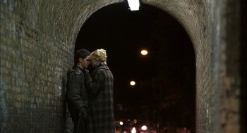 Movie still from “Notes on a Scandal” (2006), directed by Richard Eyre – A couple of people standing next to each other on a bridge; Medium shot, Over the shoulder angle