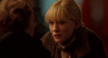 Movie still from “Notes on a Scandal” (2006), directed by Richard Eyre – A woman with blonde hair wearing a brown jacket; Close Up shot, Over the shoulder angle