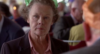 Movie still from “Notes on a Scandal” (2006), directed by Richard Eyre – An older woman with a green bow in her hair; Close Up shot, Over the shoulder angle