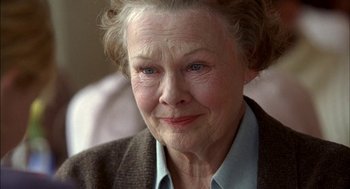 Movie still from “Notes on a Scandal” (2006), directed by Richard Eyre – An older woman with a blue shirt is looking at the camera; Close Up shot, Over the shoulder angle