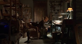 Movie still from “Notes on a Scandal” (2006), directed by Richard Eyre – A woman sitting at a desk in a room; Wide shot, High angle