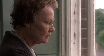 Movie still from “Notes on a Scandal” (2006), directed by Richard Eyre – An older woman looking out of a window; Close Up shot, Low angle