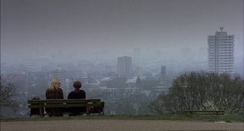Movie still from “Notes on a Scandal” (2006), directed by Richard Eyre – Two people sitting on a bench looking out over a city; Extreme Wide shot, Over the shoulder angle