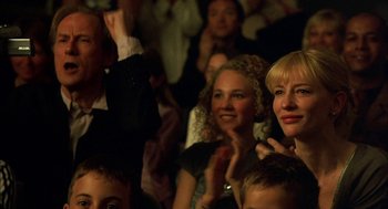 Movie still from “Notes on a Scandal” (2006), directed by Richard Eyre – A group of people sitting in a room clapping; Close Up shot, Low angle