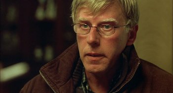 Movie still from “Notes on a Scandal” (2006), directed by Richard Eyre – A person wearing glasses and a jacket; Close Up shot, Over the shoulder angle