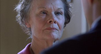 Movie still from “Notes on a Scandal” (2006), directed by Richard Eyre – An older woman looking at the camera with a serious look on her face; Close Up shot, Low angle
