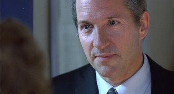 Movie still from “Notes on a Scandal” (2006), directed by Richard Eyre – A person wearing a suit and tie; Close Up shot, Over the shoulder angle