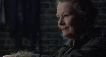 Movie still from “Notes on a Scandal” (2006), directed by Richard Eyre – An older woman sitting in front of a brick wall; Close Up shot, Over the shoulder angle