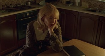Movie still from “Notes on a Scandal” (2006), directed by Richard Eyre – A woman sitting at a table in front of an open book; Medium shot, High angle