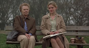 Movie still from “Notes on a Scandal” (2006), directed by Richard Eyre – Two women sitting on a park bench in a park; Medium shot, Low angle