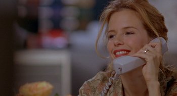 Movie still from “Nothing to Lose” (1997), directed by Steve Oedekerk – A woman smiles while talking on a phone; Close Up shot, Over the shoulder angle