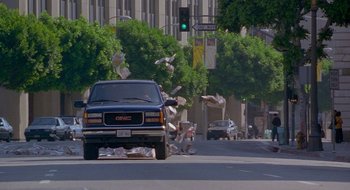 Movie still from “Nothing to Lose” (1997), directed by Steve Oedekerk – A truck driving down a street next to a traffic light; Extreme Wide shot, Low angle