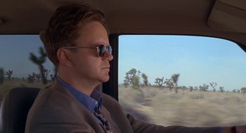 Movie still from “Nothing to Lose” (1997), directed by Steve Oedekerk – A man wearing a suit and tie driving a car; Close Up shot, Low angle