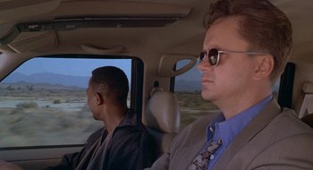 Movie still from “Nothing to Lose” (1997), directed by Steve Oedekerk – Two men sitting in the back seat of a car; Medium shot, Over the shoulder angle