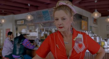 Movie still from “Nothing to Lose” (1997), directed by Steve Oedekerk – A woman in a red shirt is standing in front of a bar; Close Up shot, Low angle