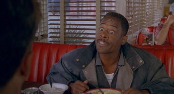 Movie still from “Nothing to Lose” (1997), directed by Steve Oedekerk – A man sitting at a table with a plate of food in front of him; Close Up shot, High angle