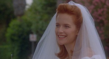 Movie still from “Nothing to Lose” (1997), directed by Steve Oedekerk – A woman in a wedding dress smiling for the camera; Close Up shot, Over the shoulder angle