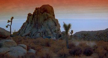 Movie still from “Nothing to Lose” (1997), directed by Steve Oedekerk – A car is parked in the middle of the desert; Extreme Wide shot, Low angle