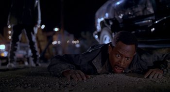 Movie still from “Nothing to Lose” (1997), directed by Steve Oedekerk – A man laying on the ground in the dirt; Close Up shot, High angle