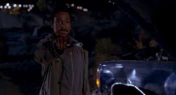 Movie still from “Nothing to Lose” (1997), directed by Steve Oedekerk – A man is holding an umbrella while standing in front of a car; Close Up shot, Over the shoulder angle