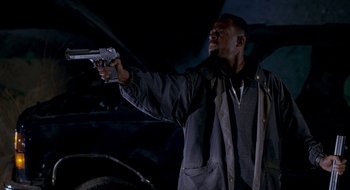 Movie still from “Nothing to Lose” (1997), directed by Steve Oedekerk – A man holding a gun in his hand; Medium shot, Low angle
