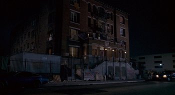 Movie still from “Nothing to Lose” (1997), directed by Steve Oedekerk – A building that has graffiti on the side of the building; Extreme Wide shot, High angle