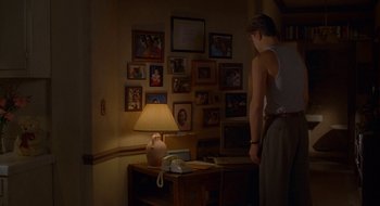 Movie still from “Nothing to Lose” (1997), directed by Steve Oedekerk – A man standing in front of a lamp in a living room; Medium shot, Over the shoulder angle