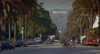Movie still from “Nothing to Lose” (1997), directed by Steve Oedekerk – A man walking a dog down a street; Extreme Wide shot, High angle