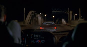 Movie still from “Nothing to Lose” (1997), directed by Steve Oedekerk – A car driving down a street at night; Wide shot, High angle