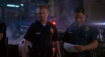 Movie still from “Nothing to Lose” (1997), directed by Steve Oedekerk – Two police officers standing next to each other on a street; Medium shot, Low angle