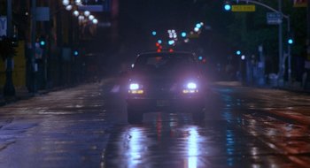 Movie still from “Nothing to Lose” (1997), directed by Steve Oedekerk – A car driving down a wet street at night; Extreme Wide shot, Low angle