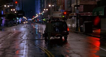 Movie still from “Nothing to Lose” (1997), directed by Steve Oedekerk – A man walking down a street at night with a car; Extreme Wide shot, High angle