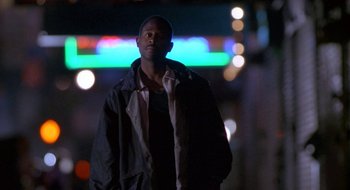 Movie still from “Nothing to Lose” (1997), directed by Steve Oedekerk – A man standing in the dark in front of a neon sign; Medium shot, Low angle