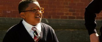 Movie still from “Notorious” (2009), directed by George Tillman Jr. – A person wearing glasses and wearing a sweater and a tie; Close Up shot, Low angle