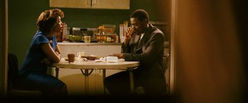 Movie still from “Notorious” (2009), directed by George Tillman Jr. – A man sitting at a table in front of food; Medium shot, Over the shoulder angle