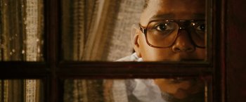 Movie still from “Notorious” (2009), directed by George Tillman Jr. – A person wearing glasses looking at a mirror; Close Up shot, Low angle