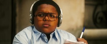 Movie still from “Notorious” (2009), directed by George Tillman Jr. – A young man wearing glasses and headphones while holding a cell phone; Close Up shot, Low angle