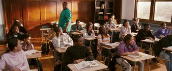 Movie still from “Notorious” (2009), directed by George Tillman Jr. – A group of people sitting at desks in a classroom; Wide shot, High angle