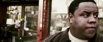 Movie still from “Notorious” (2009), directed by George Tillman Jr. – A man wearing a brown jacket and a white shirt is listening to music; Close Up shot, High angle