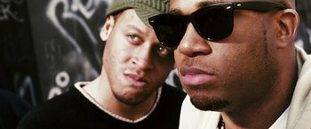 Movie still from “Notorious” (2009), directed by George Tillman Jr. – Two people wearing sunglasses and hats; Close Up shot, Low angle