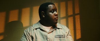 Movie still from “Notorious” (2009), directed by George Tillman Jr. – A man in a prison uniform looking off into the distance; Close Up shot, Low angle