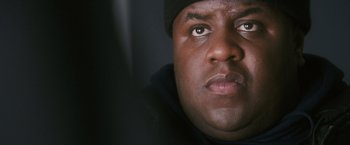 Movie still from “Notorious” (2009), directed by George Tillman Jr. – A person wearing a hat and looking at the camera; Close Up shot, Low angle