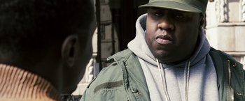 Movie still from “Notorious” (2009), directed by George Tillman Jr. – A person wearing a jacket and hat; Close Up shot, Over the shoulder angle