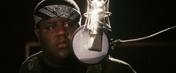 Movie still from “Notorious” (2009), directed by George Tillman Jr. – A man holding a microphone in front of his face; Close Up shot, Low angle