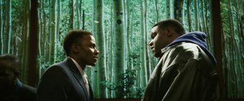 Movie still from “Notorious” (2009), directed by George Tillman Jr. – Two men in business suits talking in front of a forest; Medium shot, Over the shoulder angle