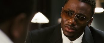 Movie still from “Notorious” (2009), directed by George Tillman Jr. – A person wearing a suit and sunglasses; Close Up shot, High angle